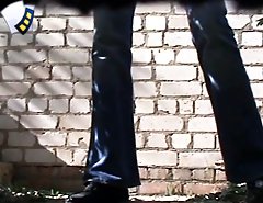 Pissing in front of a white brick wall