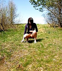 Curvaceous chick empties her bladder in the woods