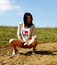 Playful teenage cutie takes a leak under the sun