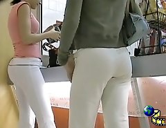 Two girlfriends are in the trading center teasing males with the tight butt jeans view