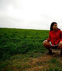 Barely legal brunette tinkling alone on a field