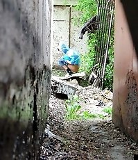 Cute gal pulls her jeans down to urinate outdoors