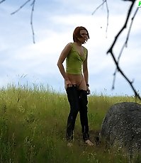 Babe tinkles on a rock in the middle of a field