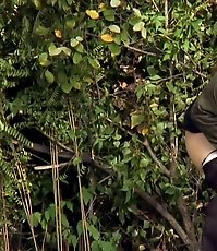 Sexy babe slyly photographed peeing behind a tree