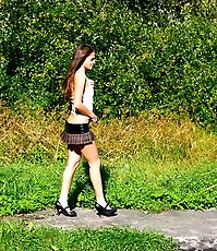 Cute young chick in checkered mini pisses outdoors