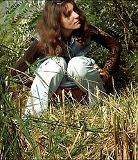 Curly hottie takes a wee under a tree