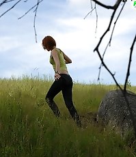 Babe tinkles on a rock in the middle of a field