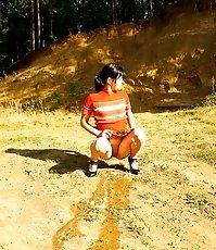 Cute tart walking down the hill squats down to pee