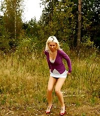 Blonde with tattooed legs pees near forest edge