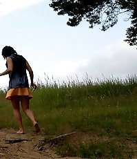 Naughty brunette pisses into a sandpit in forest