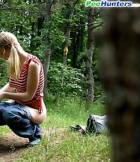 Young cute blondie waters the grass with her piss