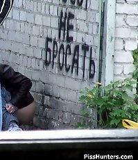 Girl peeing while a guy screens her from glances