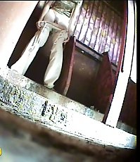 Two girls watering the spy cam planted in park loo