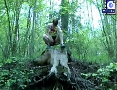 Red-haired hoochie pees off a hill in the woods