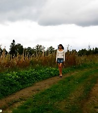 Cute brunette babe pisses up a storm in the field